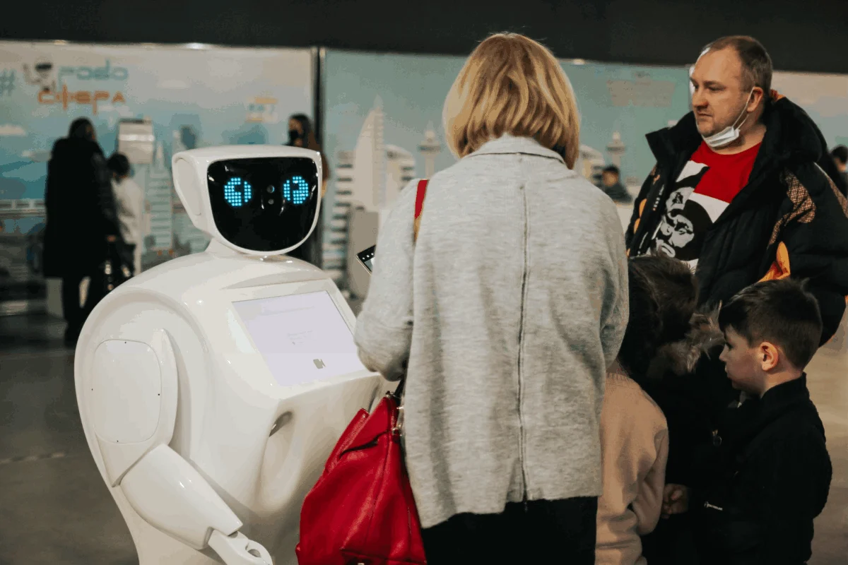 A humanoid robot standing among conference attendees