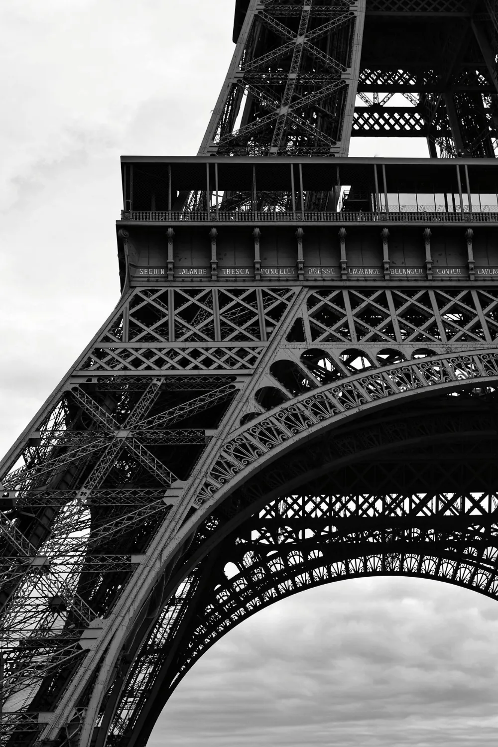 The Eiffel Tower in black and white, seen from below against a clear sky
